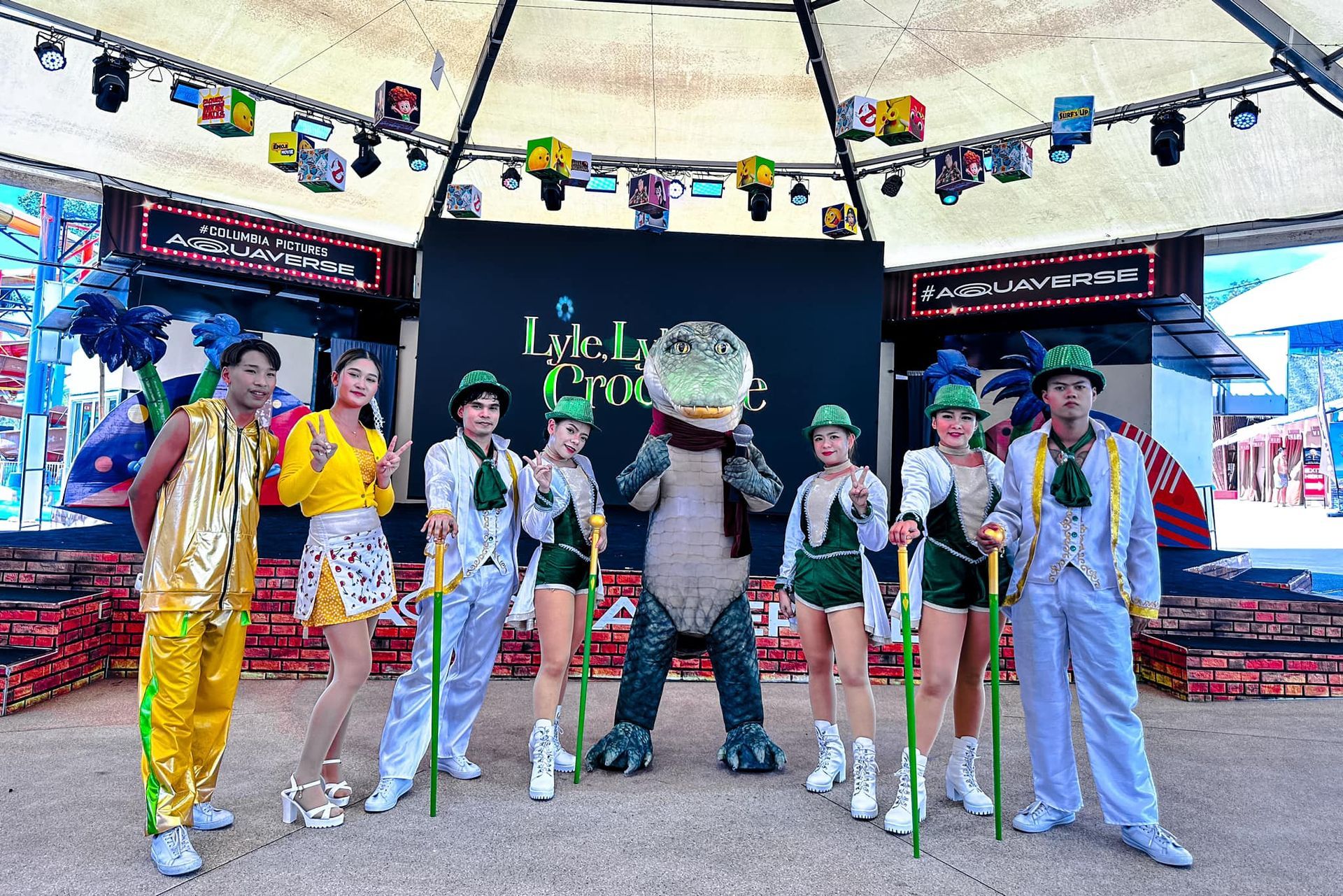 A group of people standing next to a crocodile mascot.