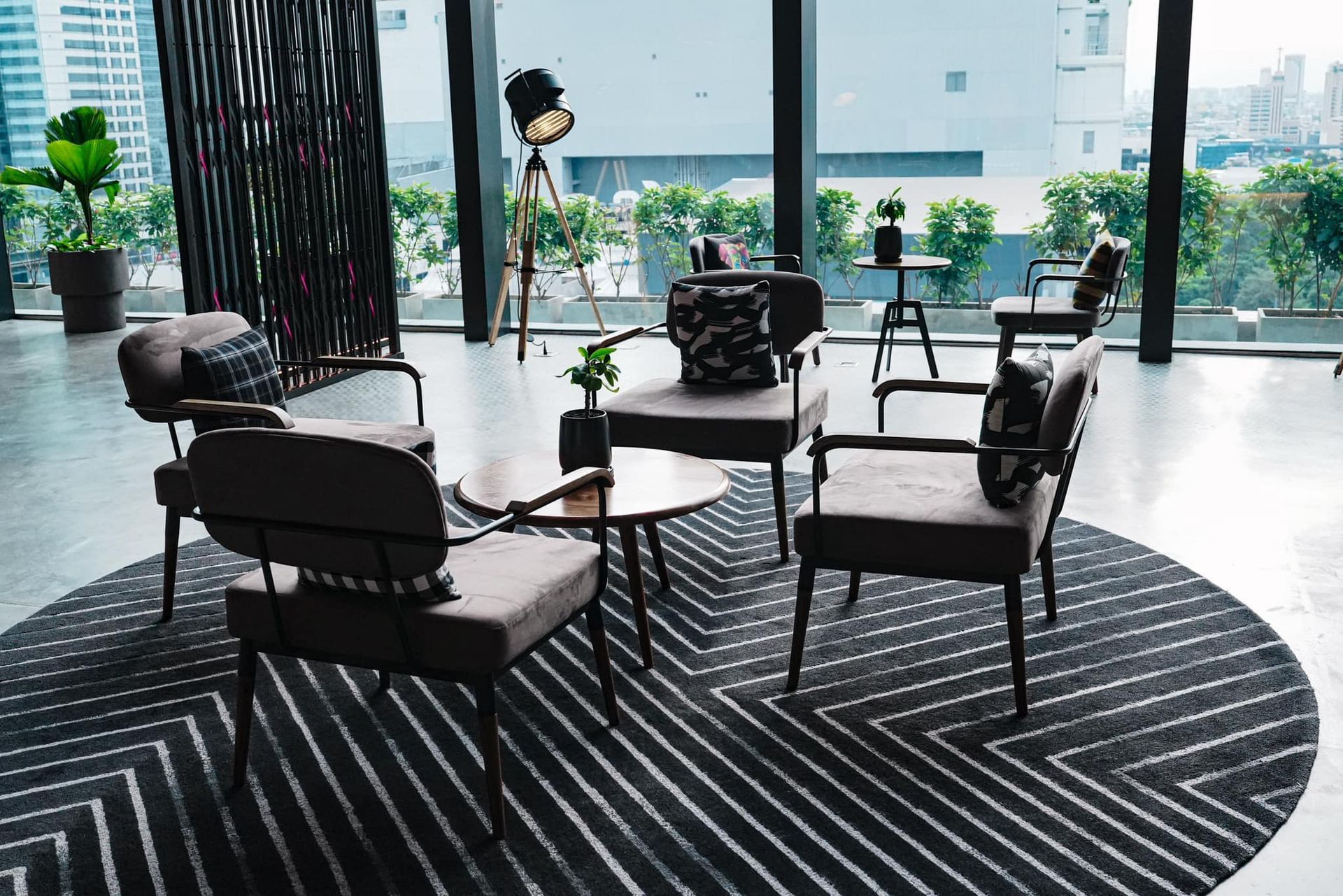 A living room with chairs , a table and a rug.