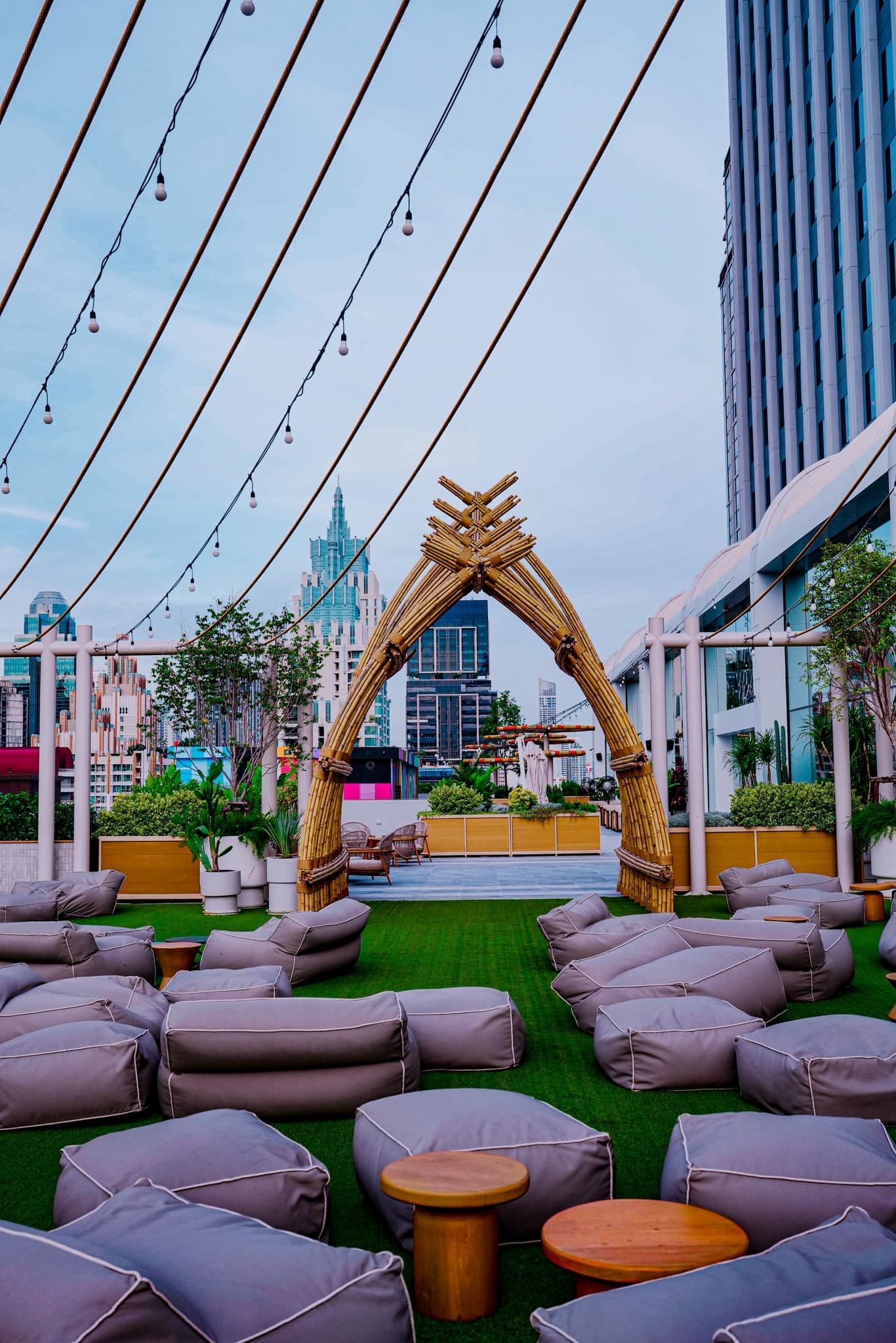 There are a lot of bean bags and tables on the grass.