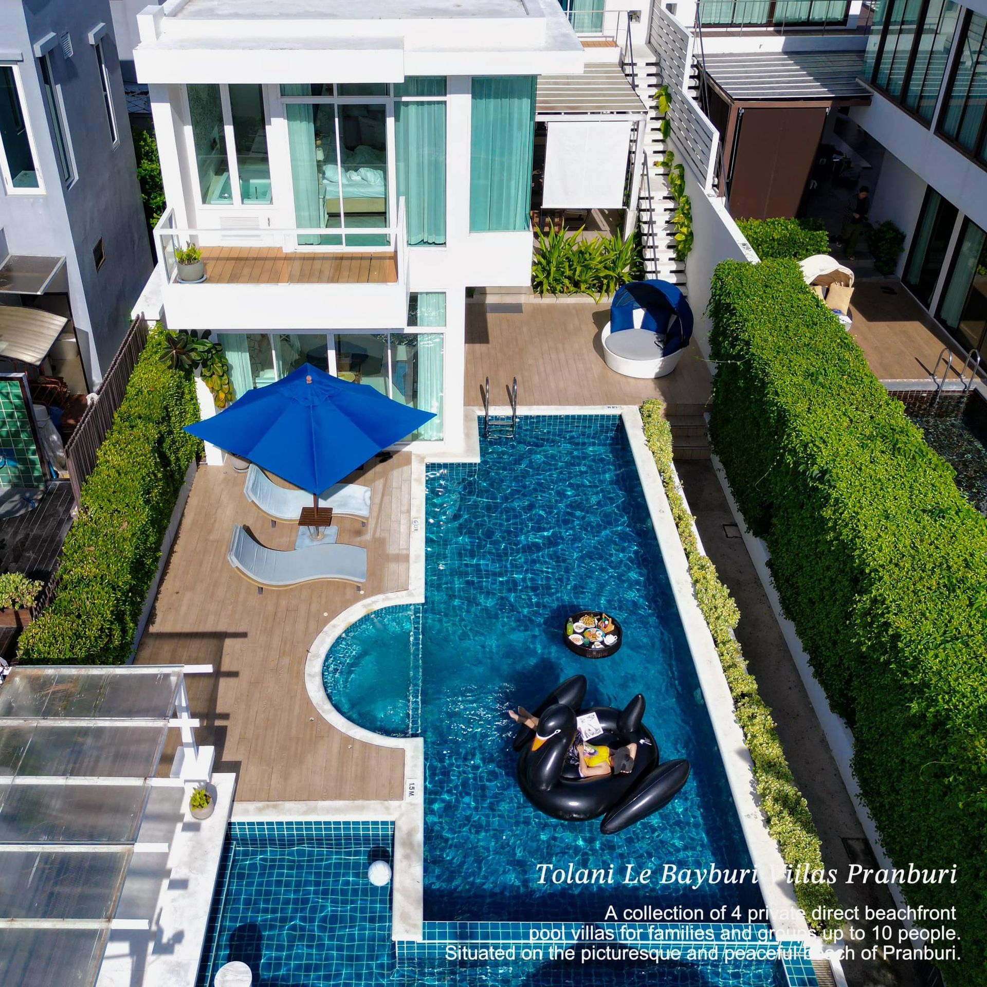 An aerial view of a house with a large swimming pool