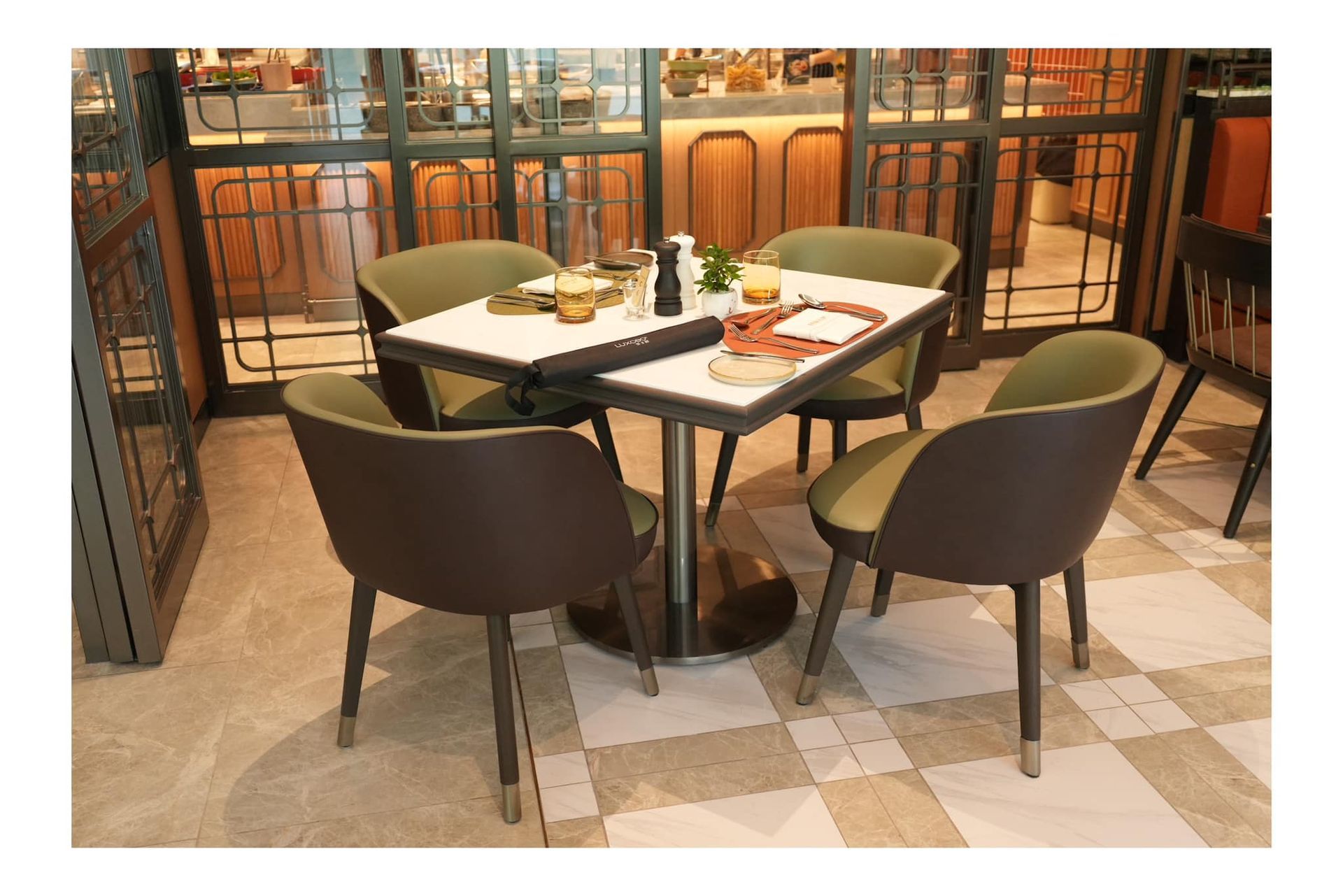 A table and chairs in atrium restaurant with a checkered floor.