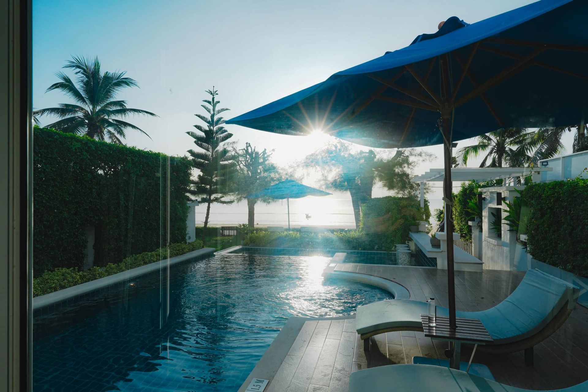 A swimming pool with umbrellas and chairs next to it
