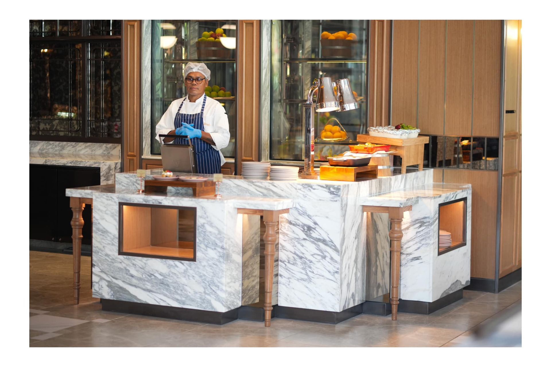 A chef is standing at a counter in a restaurant.