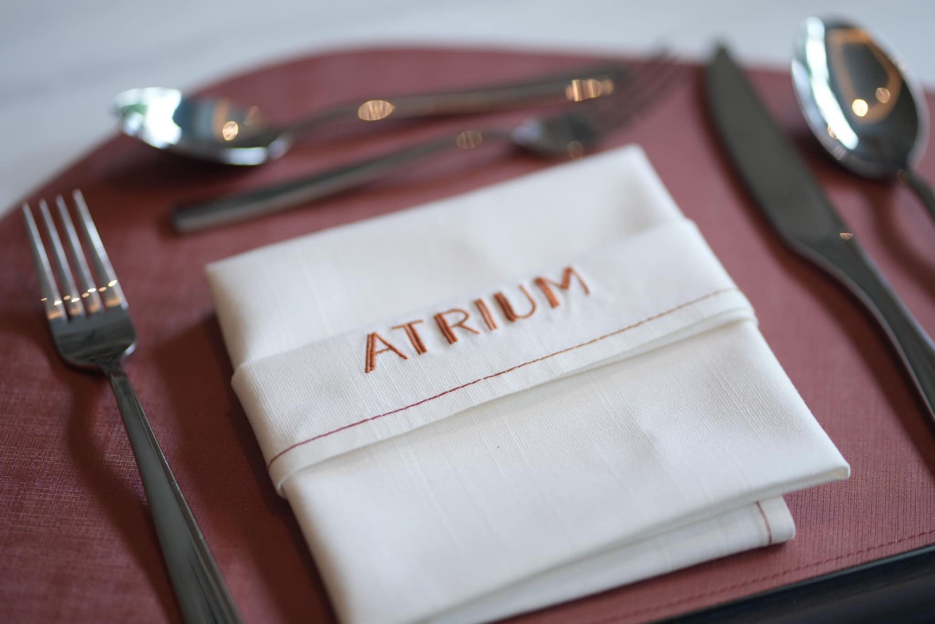 A napkin with the word atrium embroidered on it