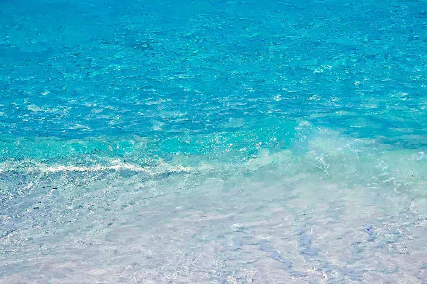 A close up of a blue ocean with waves crashing on the shore on similan islands.