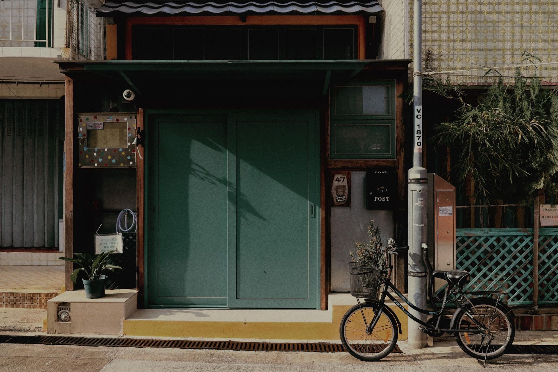 A bicycle is parked in front of a green building.