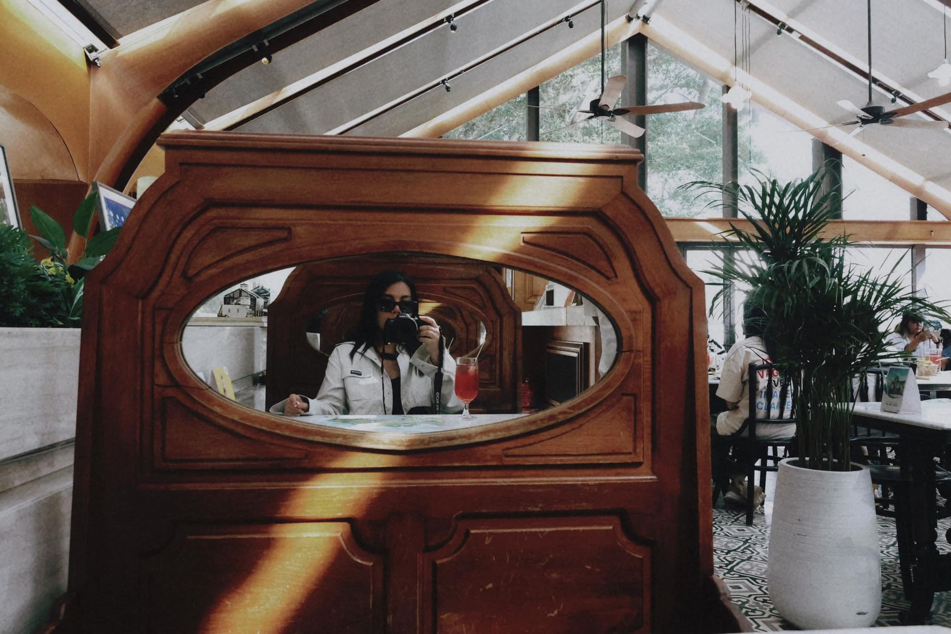 A woman is taking a picture of herself in a mirror in a restaurant.