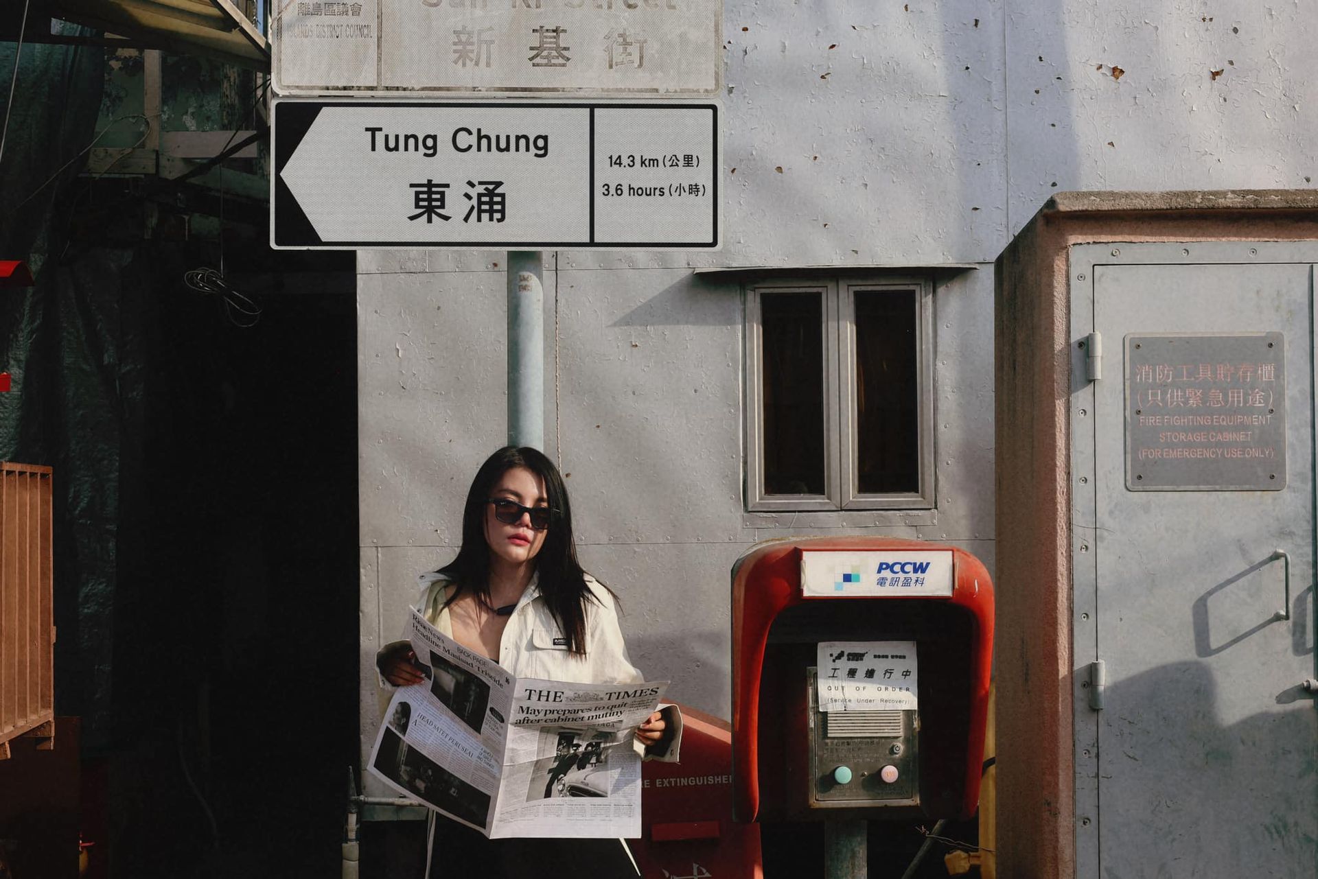 A woman standing in front of a sign that says tung chung
