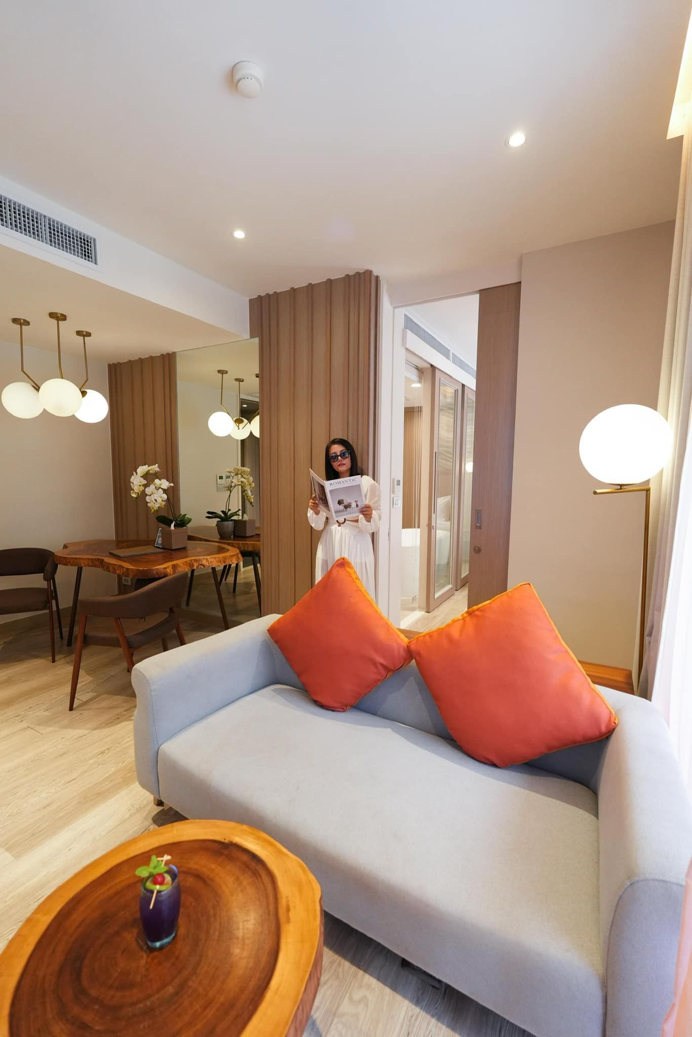 A woman is standing in a living room next to a couch.