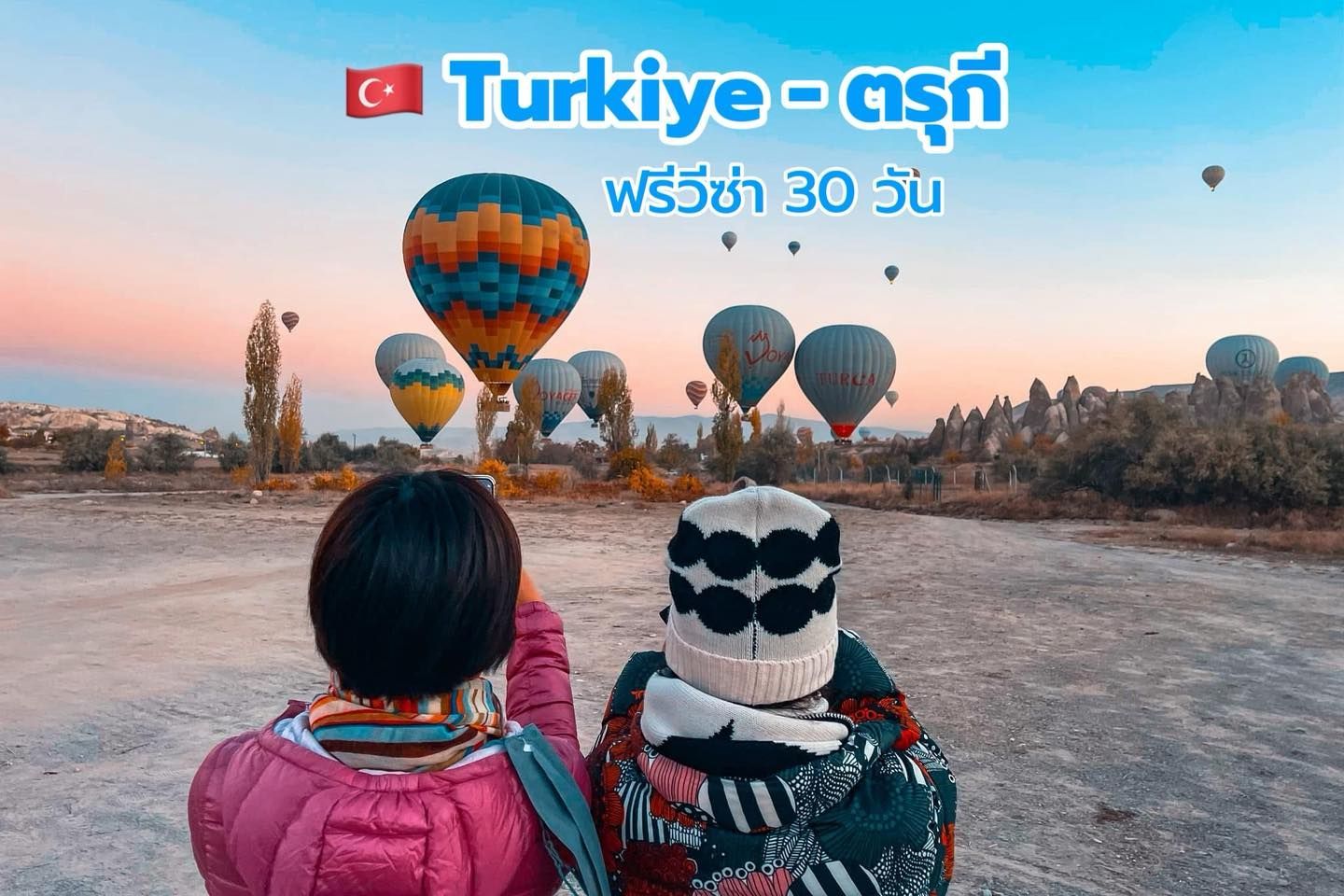 Two people watching hot air balloons in Cappadocia, Turkey. Sunset colors. Text: 