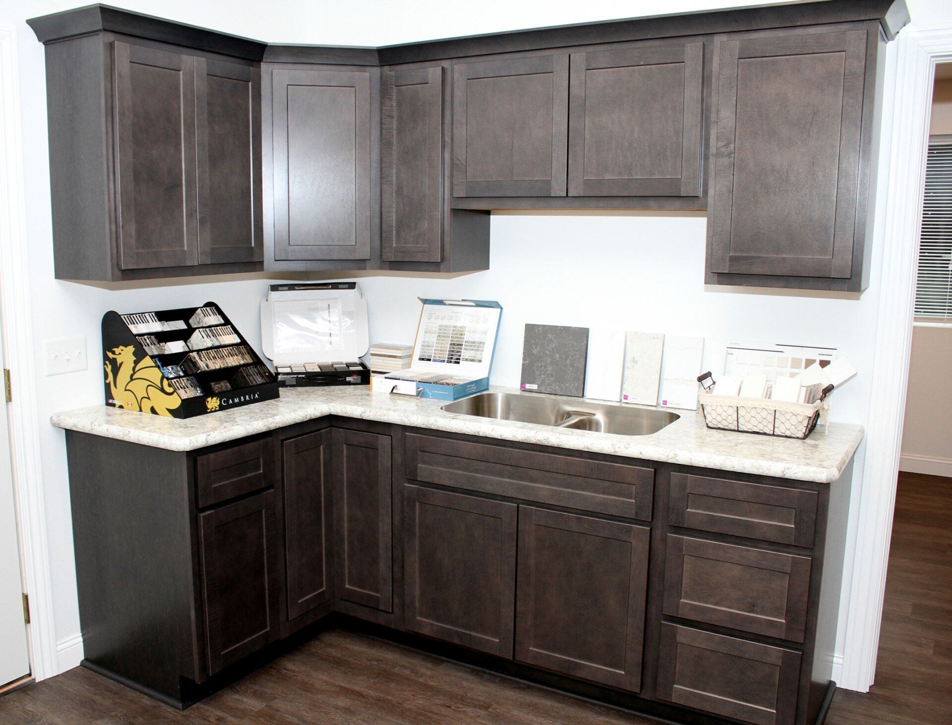 Dark gray kitchen cabinets with a light countertop.
