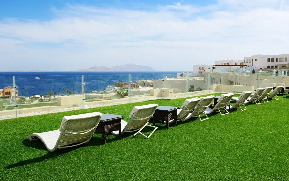 Large artificial grass lounge area at a luxury seaside resort.