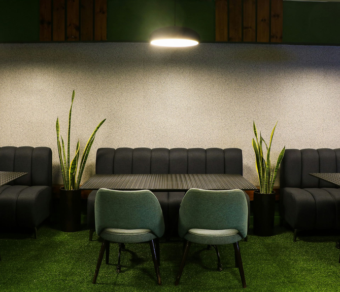 Worker using a utility knife to trim the edge of a new turf roll.