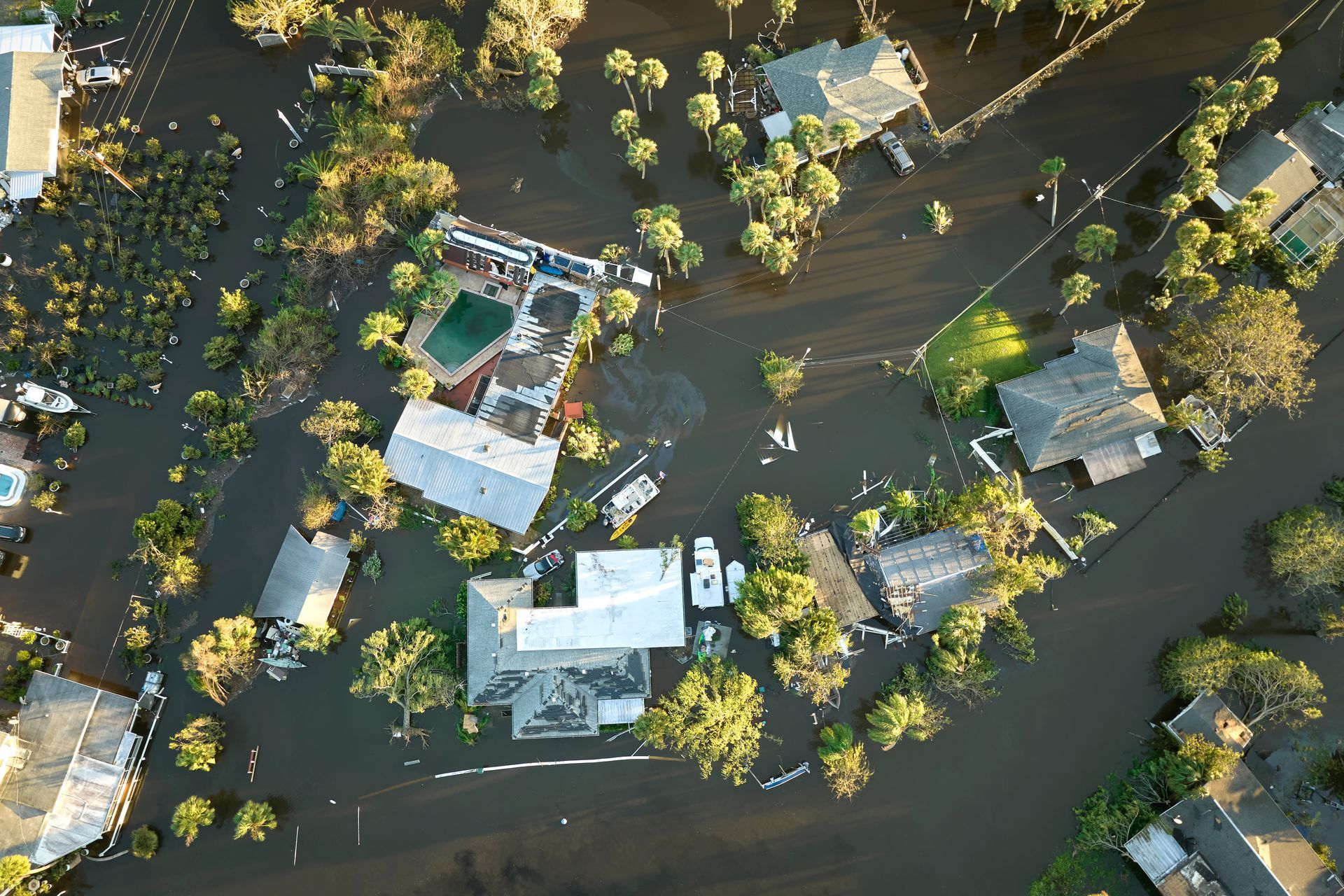 An aerial view of a flooded neighborhood with houses and trees
