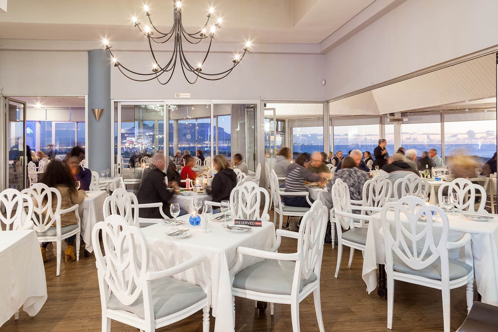 A group of people are sitting at tables in a restaurant.