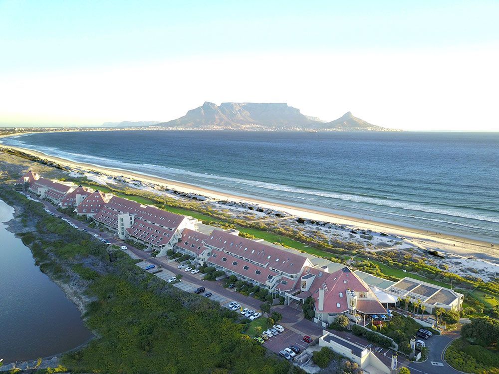 An aerial view of a beach with a mountain in the background.