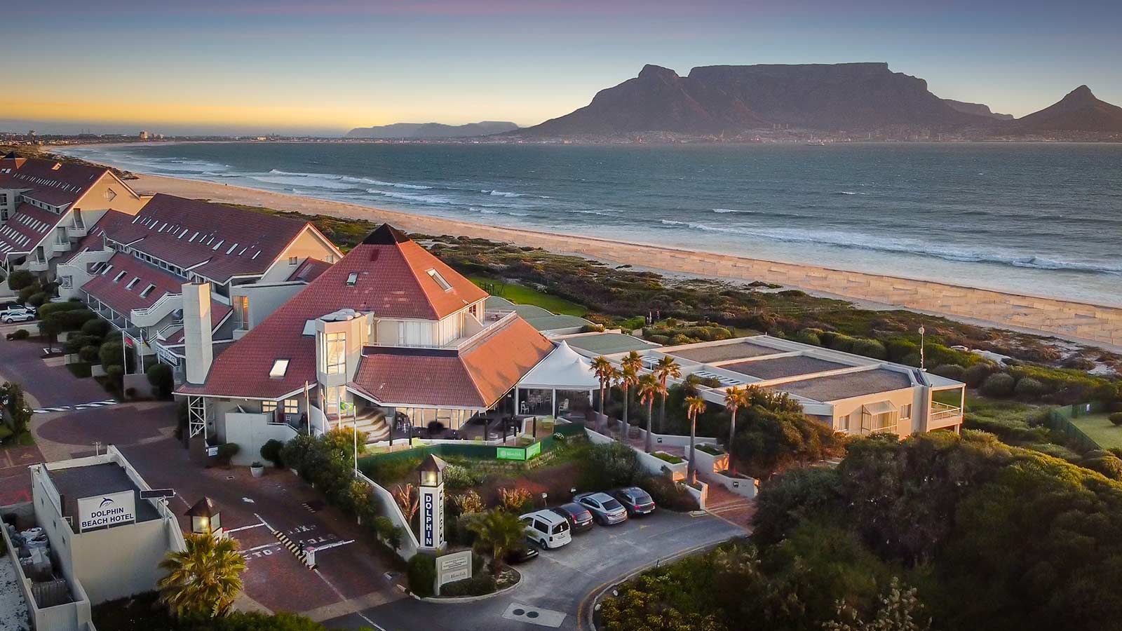 An aerial view of a beach resort with a mountain in the background.