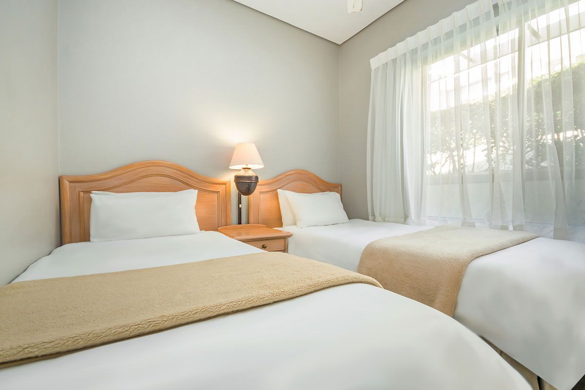 Ein Hotelzimmer mit zwei Betten und einem Fenster.