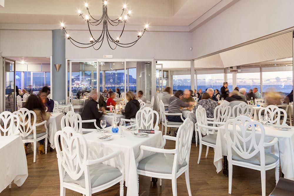 A group of people are sitting at tables in a restaurant.