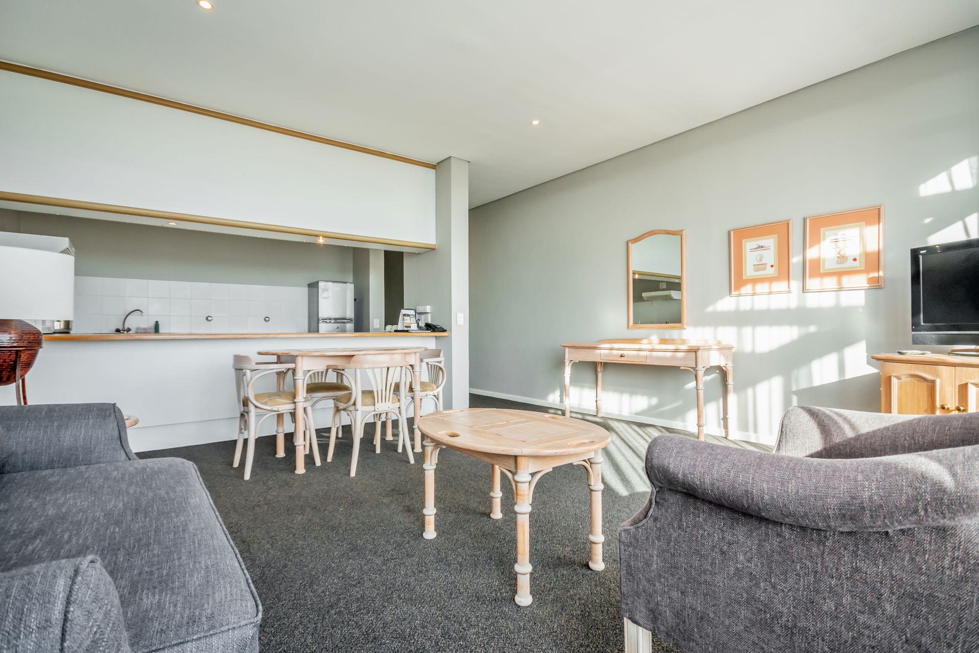 A living room with a couch , table and chairs