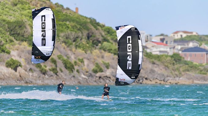 A group of people are flying kites in the ocean.