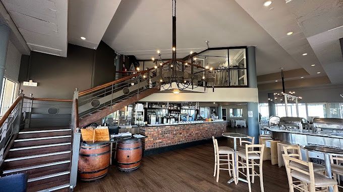 A large restaurant with a staircase leading up to the second floor.