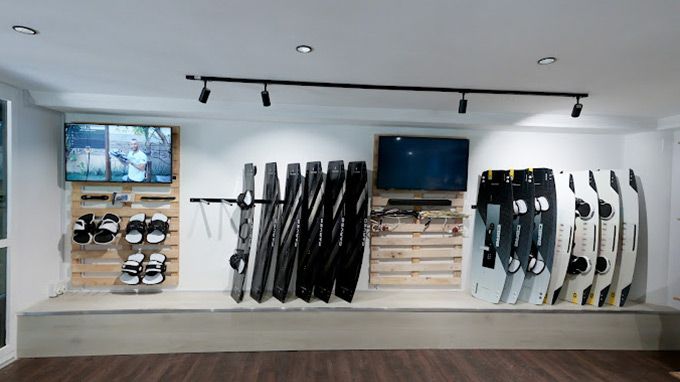 A room with a lot of skis and a tv on the wall.