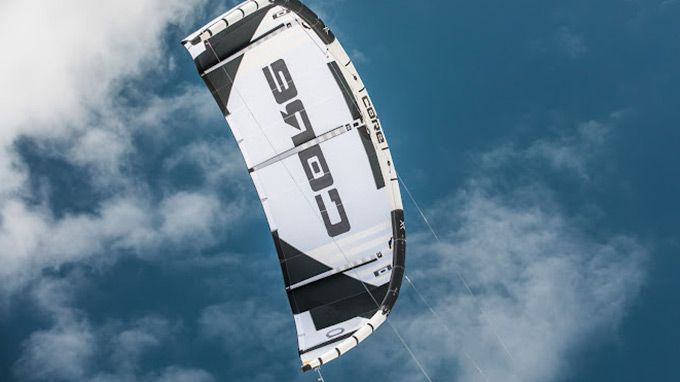 A black and white kite is flying in the sky.