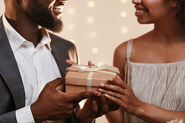 A man is giving a gift to a woman.