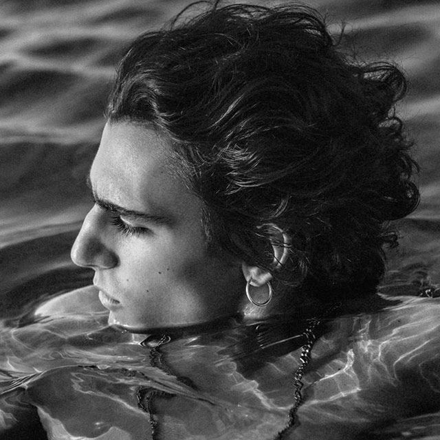 A black and white photo of a man swimming in the water.