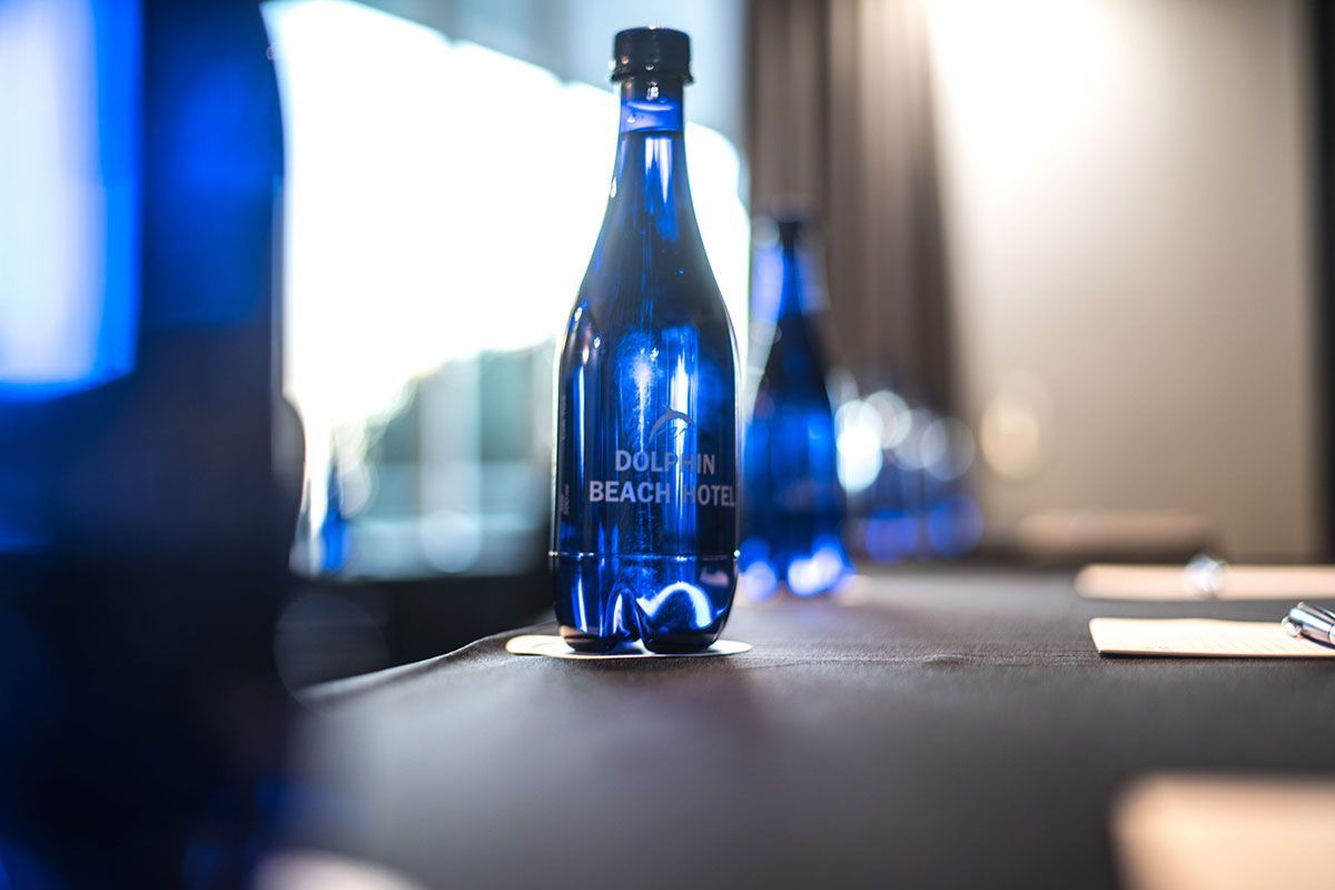 Eine Flasche Wasser steht auf einem Tisch in einem Konferenzraum.