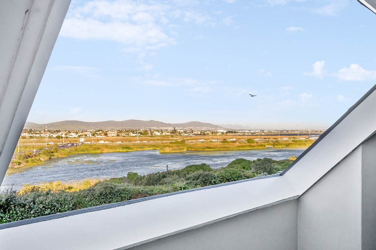 Ein Fenster mit Blick auf einen See und die Berge