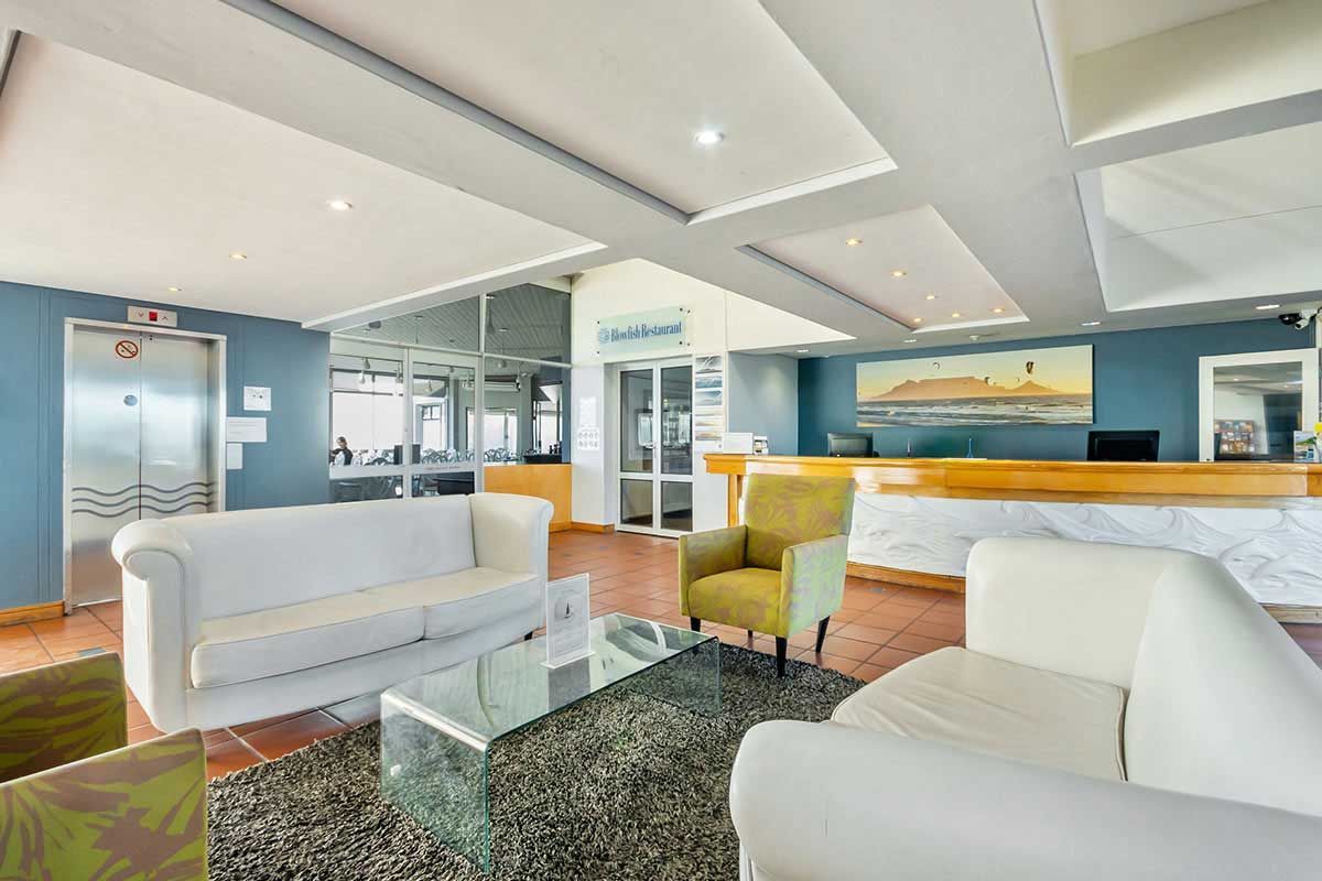 Eine Hotellobby mit Sofa, Stühlen und Theke.