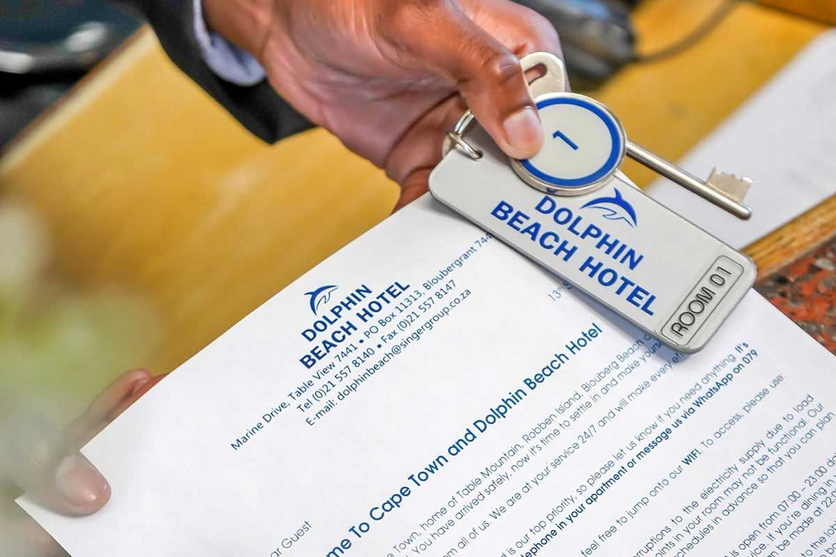 Eine Person hält einen Schlüssel vom Dolphin Beach Hotel