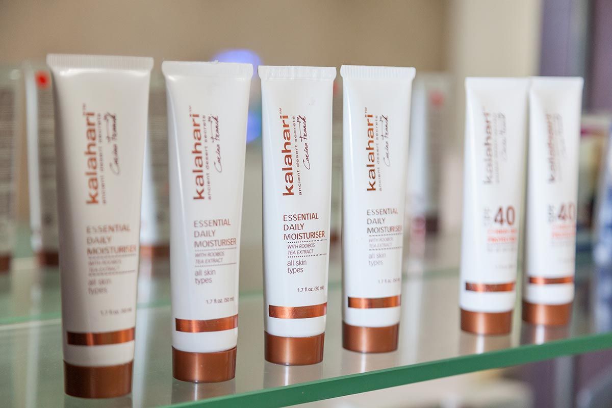 Eine Reihe von Kalahari-Produkten ist auf einem Glasregal aufgereiht