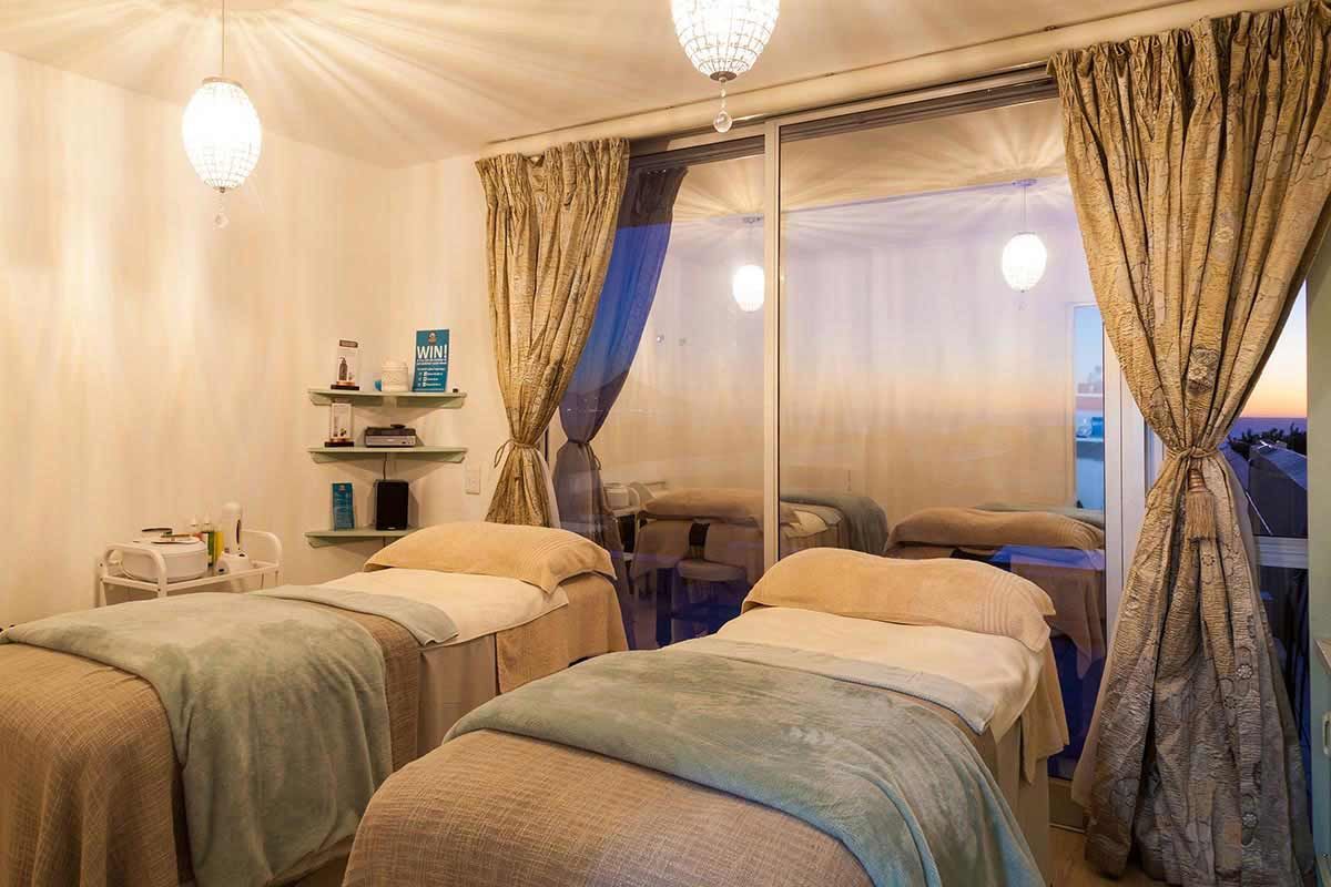 Ein Zimmer mit zwei Betten und einer Glasschiebetür.