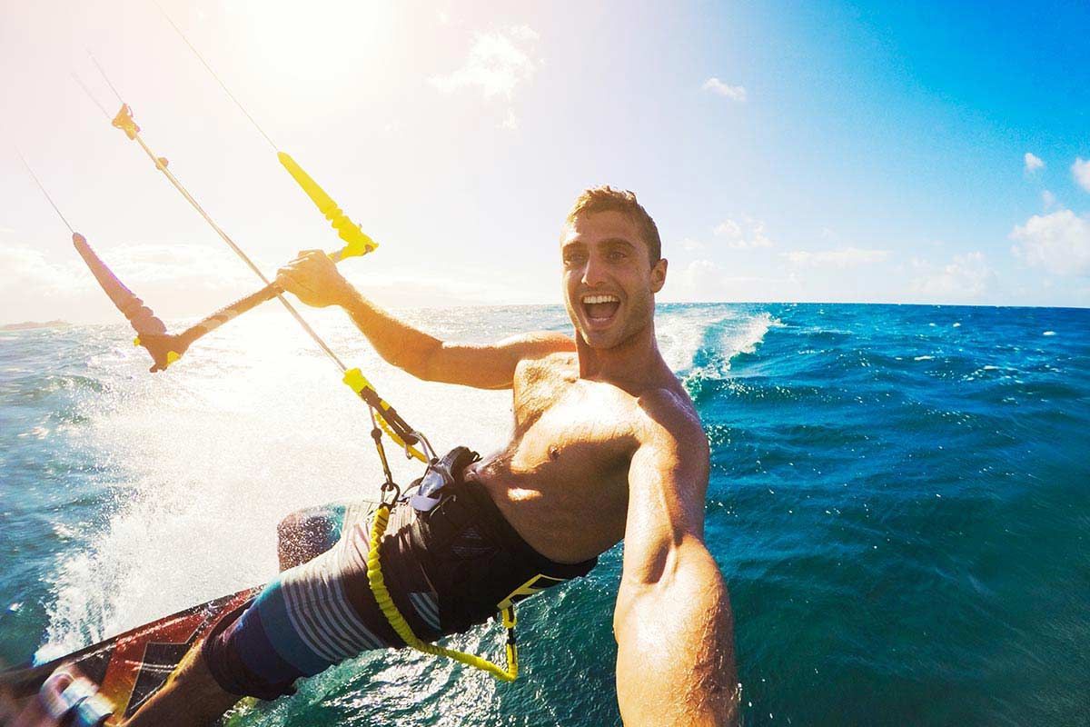 Ein Mann lässt im Meer einen Drachen steigen.