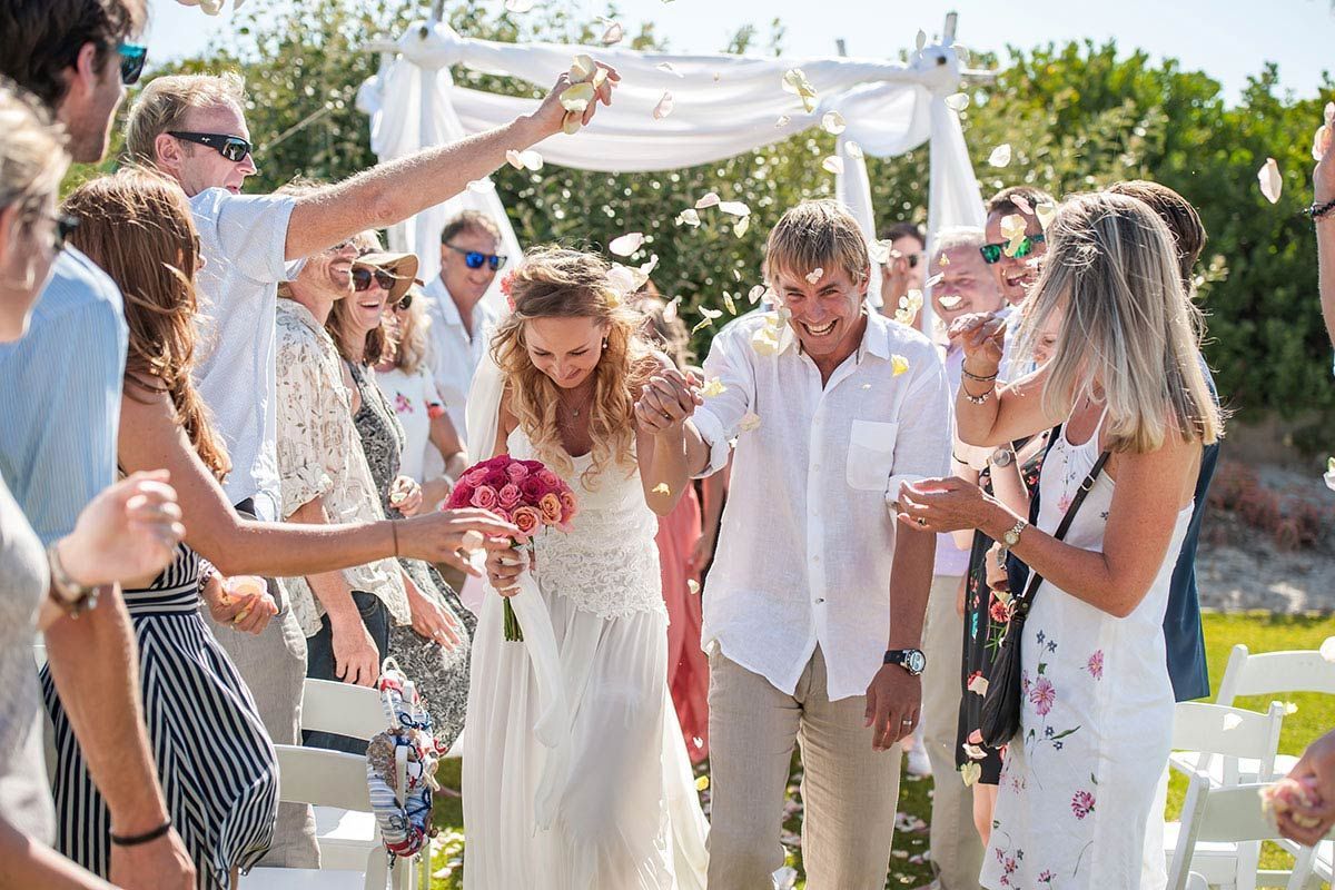 A bride and groom are walking down the aisle at their wedding.