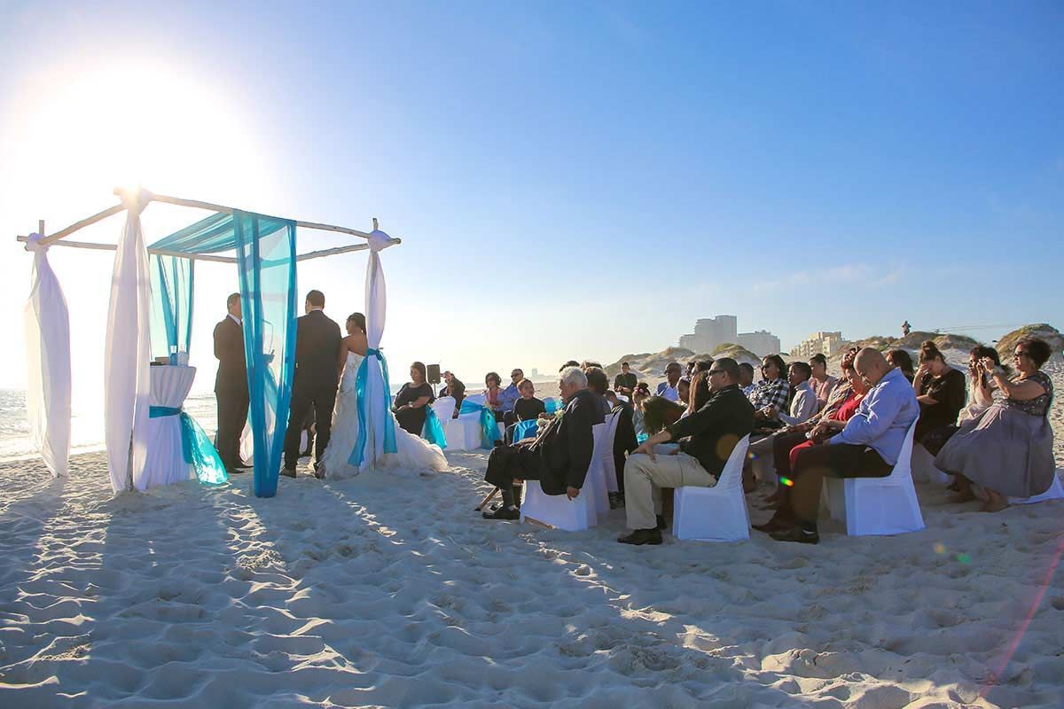 A wedding ceremony is taking place on the beach.