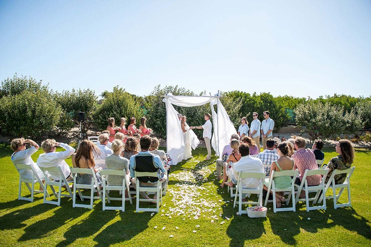 A group of people are sitting in chairs watching a wedding ceremony.