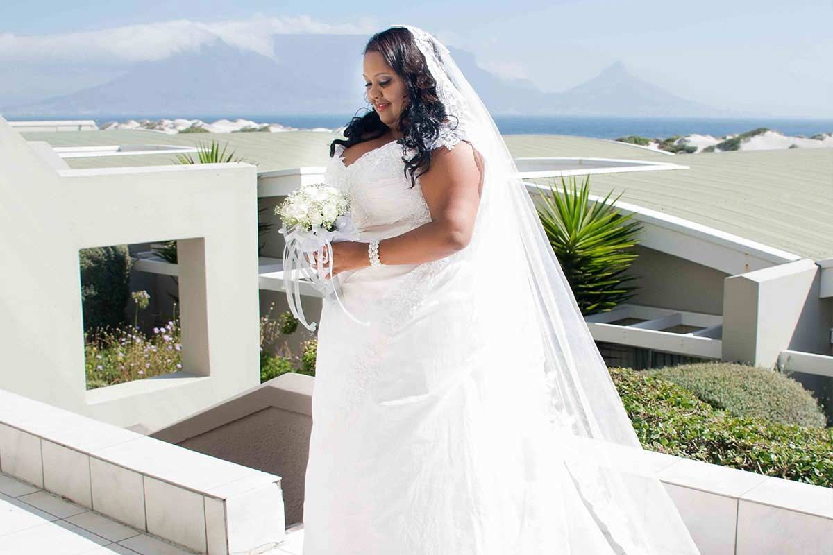 A woman in a wedding dress is holding a bouquet of flowers.
