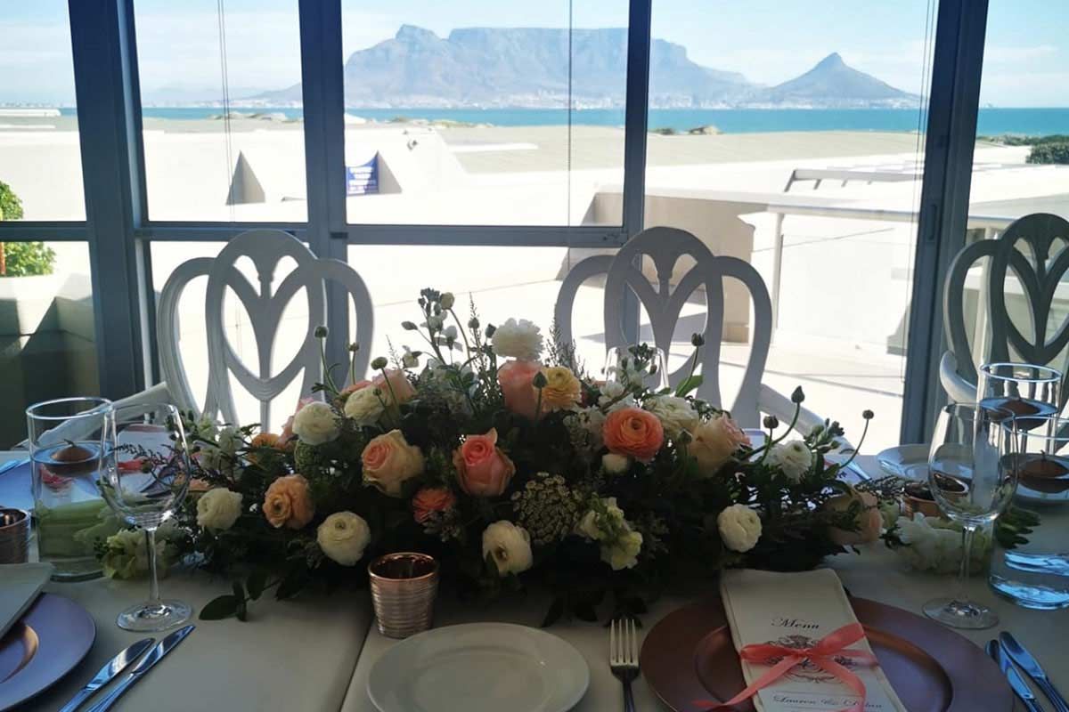 A table with flowers on it and a mountain in the background