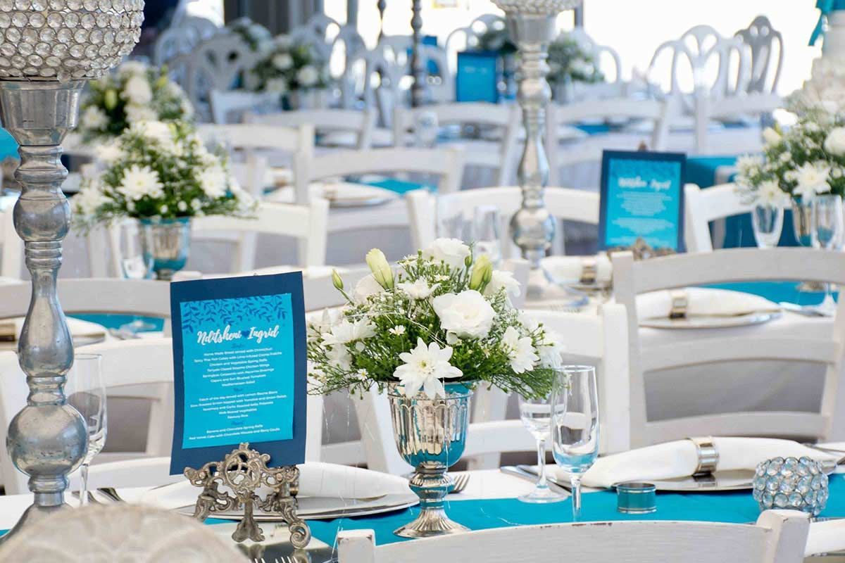 A table set for a wedding reception with blue and white decorations