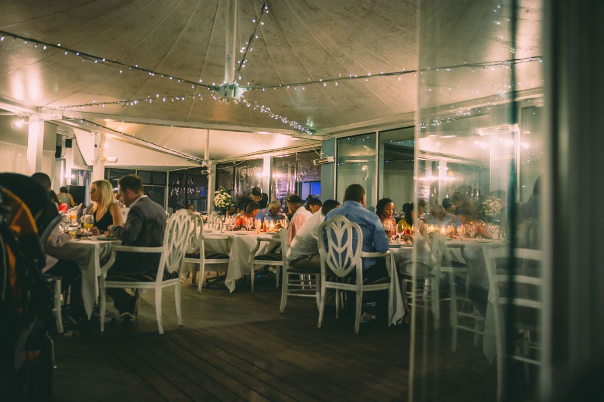 A group of people are sitting at tables in a restaurant.