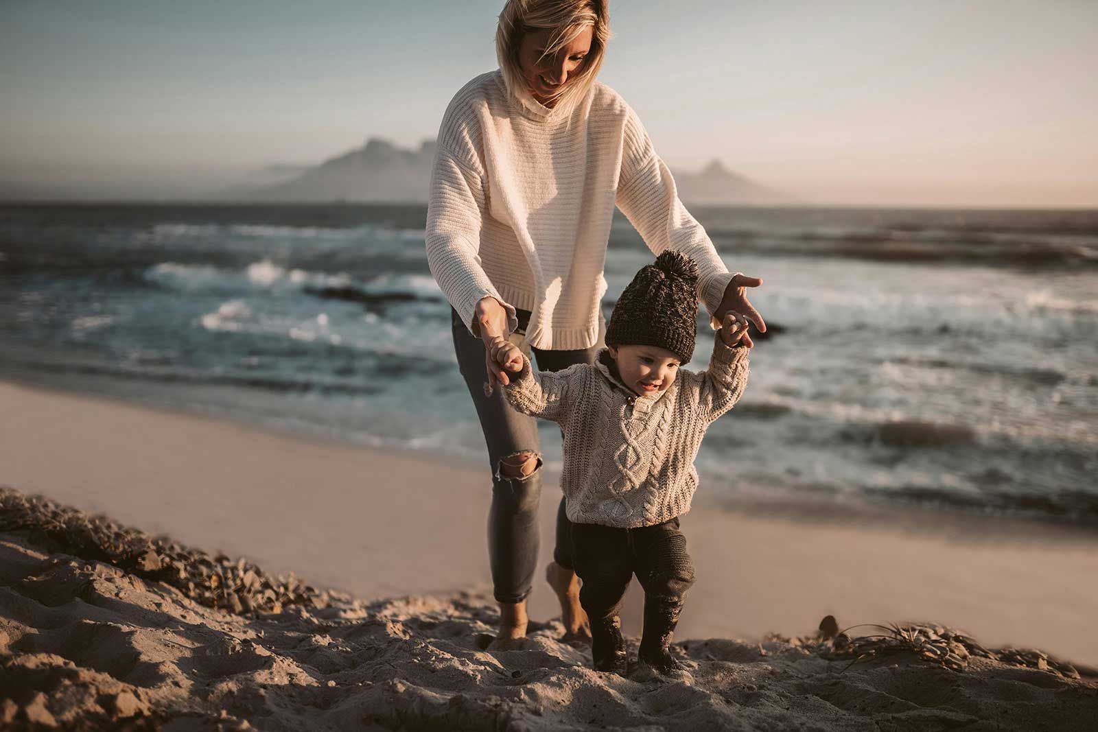 Una donna e un bambino camminano sulla spiaggia.