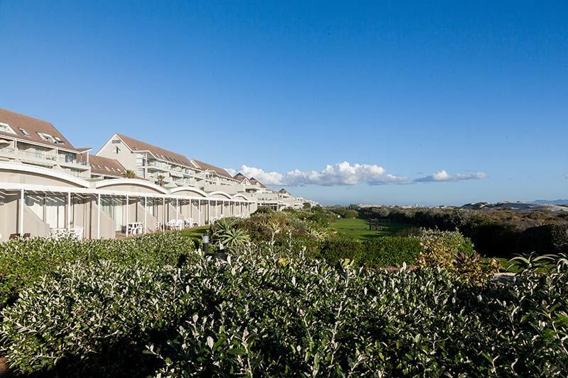 A row of white houses with a blue sky in the background.