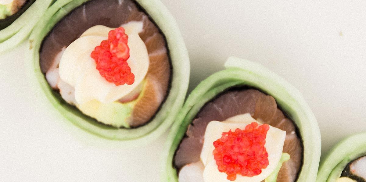 A close up of a sushi roll with caviar on top.