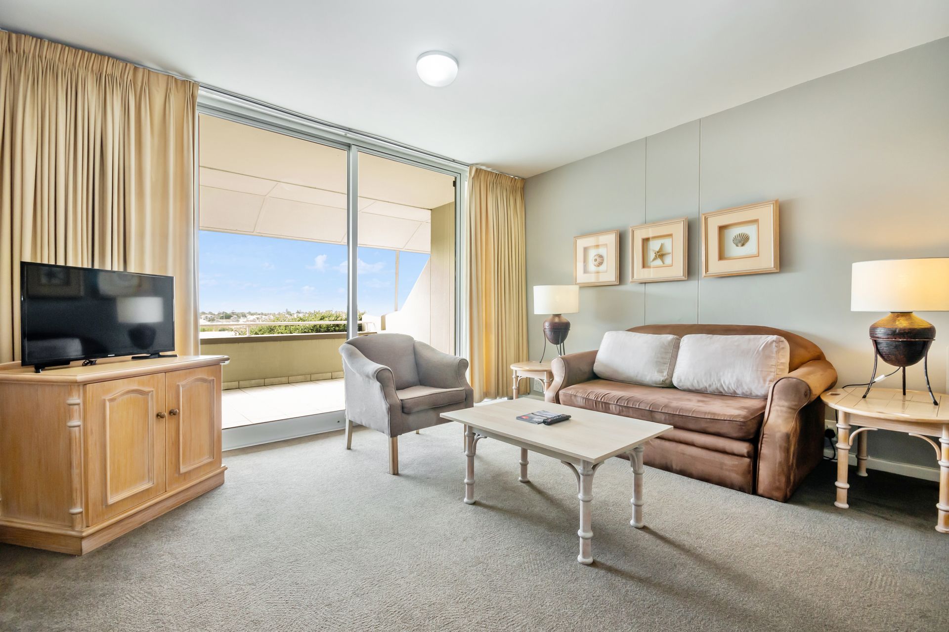 A living room with a couch , chair , coffee table and television.