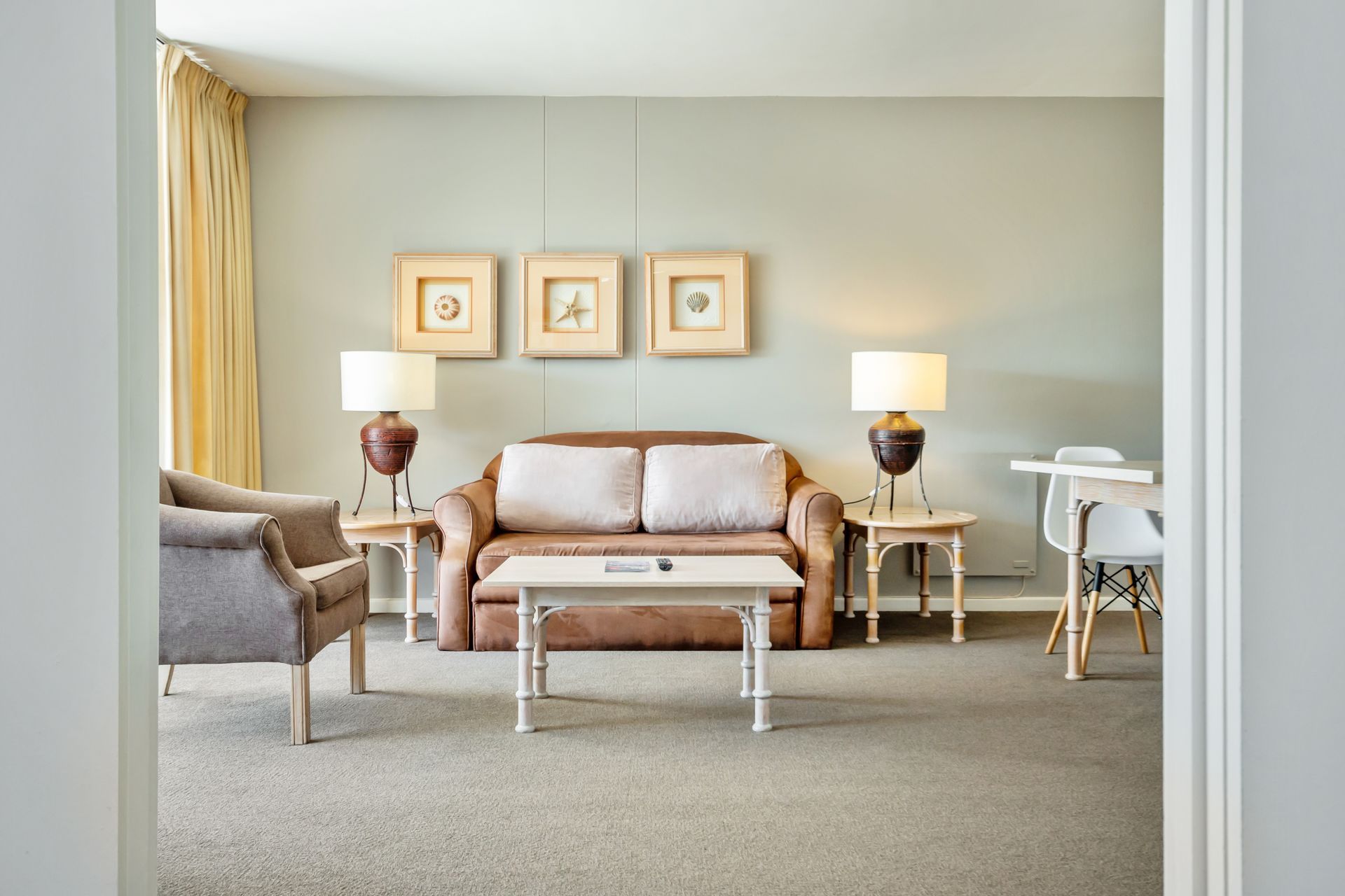 A living room with a brown couch and a white coffee table