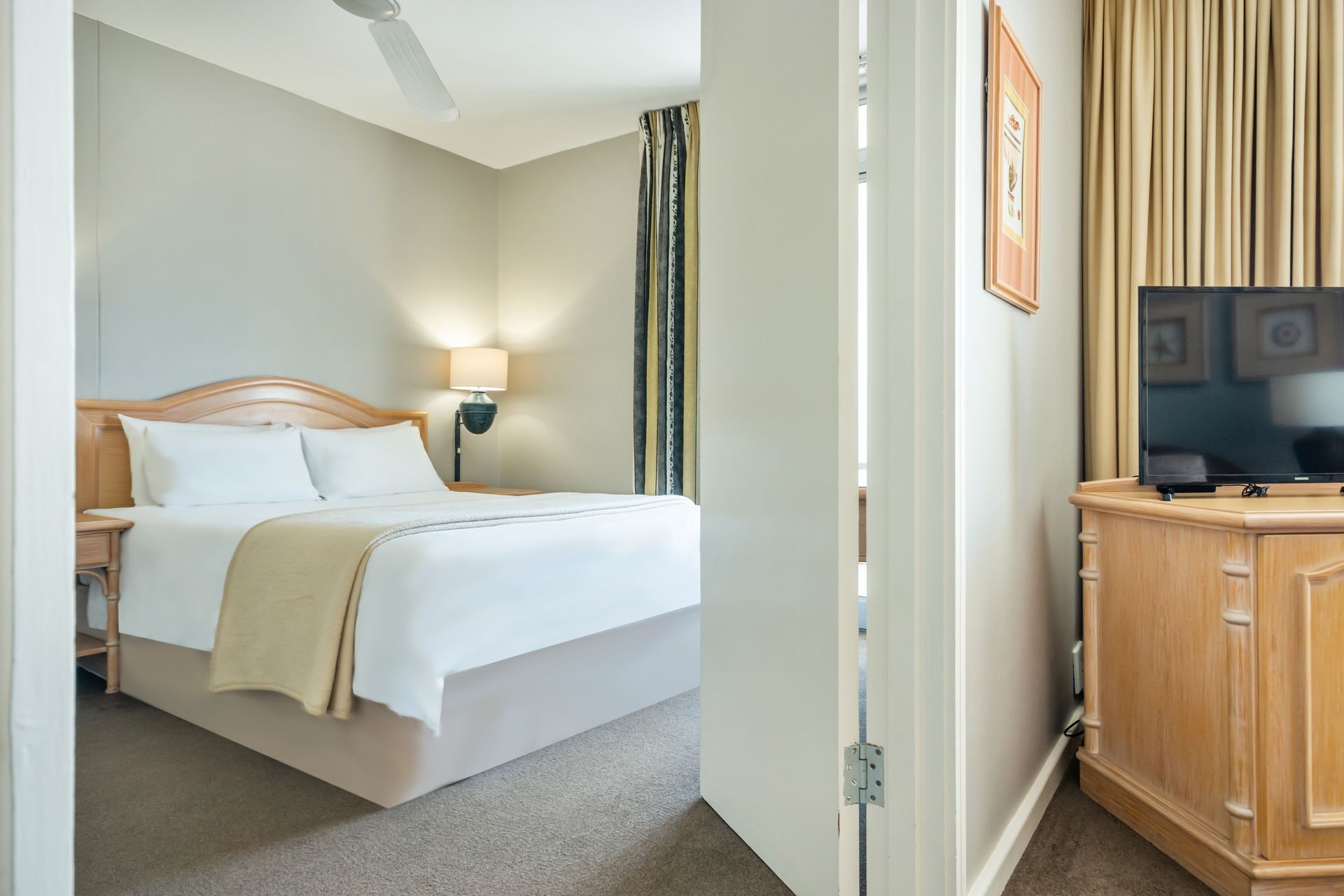 A hotel room with a king size bed and a flat screen tv.